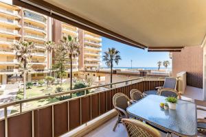 Un balcón con mesa y sillas y vista a la playa. en Doña Sofía, en Fuengirola