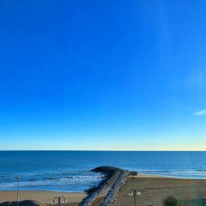 a view of the ocean with a pier on the beach at Eurobeach Residence in Cavallino-Treporti