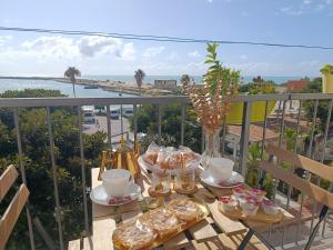 a table on a balcony with a view of the ocean at Vacanze Mariu' in Porto Empedocle