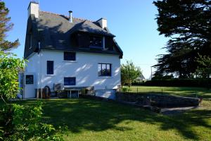 a white house with a black roof at Maison 100m de la plage in Trégunc
