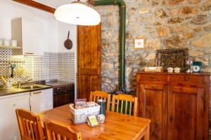 - une cuisine avec une table en bois et un mur en pierre dans l'établissement Birbina - Poggio alle Birbe, à Il Bagno 22 autres photos