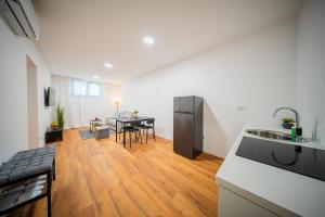 een keuken en woonkamer met een tafel en een spoelbak bij Flex SelfCheckIns 188 - Zagreb - 2 Bedrooms - Parking in Zagreb +16 foto's