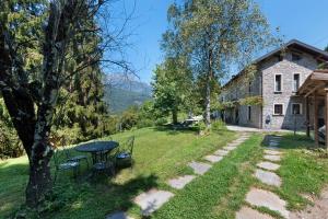 a picnic table in the yard of a house at Casale La Selva Cottege grande in Piano Porlezza