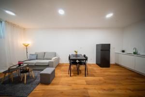 een woonkamer met een bank en een tafel bij Flex SelfCheckIns 188 - Zagreb - 2 Bedrooms - Parking in Zagreb