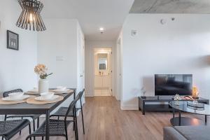een woonkamer met een eettafel en een tv bij Downtown Montreal 1BR - Sleeps 4 in Montreal