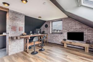 Una habitación con una pared de ladrillo con un escritorio y un televisor. en Industrial, en Schloss Holte-Stukenbrock