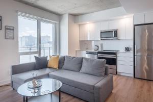 een woonkamer met een bank en een tafel en een keuken bij Downtown Montreal 1BR - Sleeps 4 in Montreal