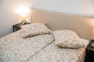 een bed met twee kussens erop bij Flex SelfCheckIns 188 - Zagreb - 2 Bedrooms - Parking in Zagreb