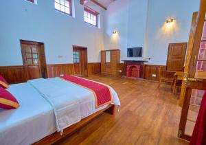 乌提Shivvs Heritage Resort Ooty的一间带床和壁炉的大卧室 更多34张照片