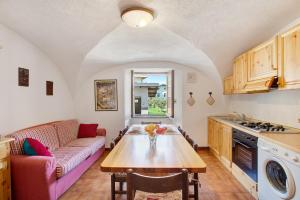 une cuisine et un salon avec une table et un canapé dans l'établissement Caratteristico e accogliente, à Pila