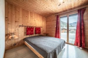 a bedroom with a bed in a room with a window at Sherpa - 10 pers in Saint-Jean-dʼAulps