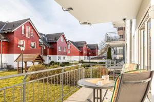 a balcony with a table and chairs and red houses at Ferienwohnung Tannenblick 1-1 in Oberhof
