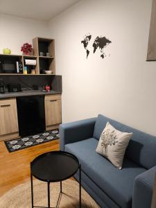 a living room with a blue couch and a table at L'appart de Cécile in Bellegarde-sur-Valserine