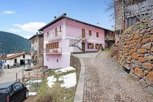 a pink house with a car parked in front of it at Appartamento Alessio in Sicina