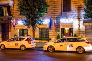 dois táxis amarelos estacionados em frente a um hotel em Hotel Emmaus em Roma