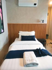 una stanza d'albergo con un letto con un asciugamano sopra di Dancenter Airport Hotel - Grey Hotel a Santol