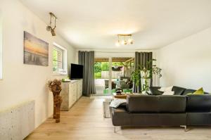 a living room with a couch and a television at Möwchen in Berumbur