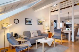 ein Wohnzimmer mit Sofa, Stühlen und einem Tisch in der Unterkunft Ferienwohnung Rieslehof Nr9 in Titisee