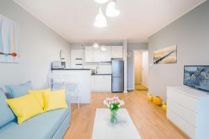 un salon avec un canapé bleu et une cuisine dans l'établissement Przestronny Apartament z Tarasem i Parkingiem w Gdyni by Noclegi Renters, à Pogórze