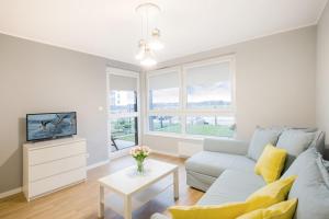 un salon avec un canapé et une télévision dans l'établissement Przestronny Apartament z Tarasem i Parkingiem w Gdyni by Noclegi Renters, à Pogórze
