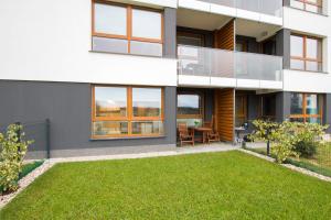 une maison avec une pelouse devant dans l'établissement Przestronny Apartament z Tarasem i Parkingiem w Gdyni by Noclegi Renters, à Pogórze