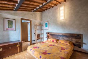 a bedroom with a bed with a wooden head board at Casa di Franca a San Galgano in Chiusdino