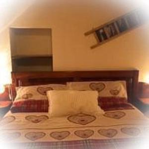 a bed with a wooden headboard in a bedroom at Maison Perruchon in Pont-Saint-Martin