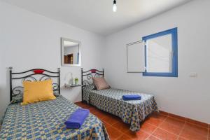 a bedroom with two beds and a window at La Caletilla La Graciosa in Caleta de Sebo