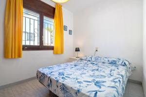 a bedroom with a bed and a window with yellow curtains at Coma-ruga in El Vendrell +18 photos