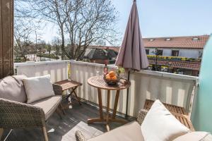 eine Terrasse mit einem Tisch und einem Sonnenschirm auf dem Balkon in der Unterkunft Ferienwohnung Kille-rechte Wohnung in Sankt Peter-Ording