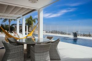 eine Terrasse mit einer Hängematte und einem Pool in der Unterkunft Villa Palacio Nazari in Málaga