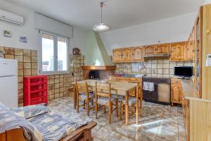 een keuken met houten kasten en een tafel en stoelen bij Casa Sofia in Torre Pali  +9 foto's