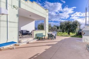 een patio met een groene bank en tafels bij Casa Sofia in Torre Pali 