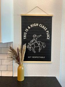 a sign for a horse race on a wall with a vase at Charming 1BR Retreat - Walk to Gruene Hall Upscale Amenities in Gruene