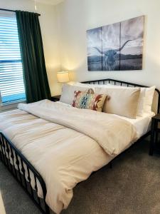 a large bed in a bedroom with two paintings on the wall at Charming 1BR Retreat - Walk to Gruene Hall Upscale Amenities in Gruene