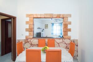 a dining room table with orange chairs and a mirror at Apartment Sweet Dreams in Sutivan