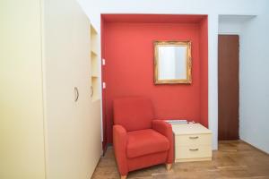 a red chair and a desk in a room at Apartment Sweet Dreams in Sutivan