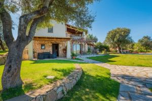 una casa con un árbol y un camino de piedra en Appartamento 2 in Villa in campagna, en Olbia