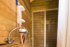 a shower with a shower head in a wooden bathroom at Cabin - Sleeps 6 - Pets Ok - Pato - Parking in Ørnes