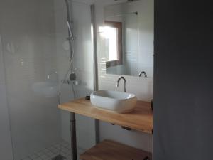 une salle de bain blanche avec lavabo et douche dans l'établissement La Maison De Pierre, à La Chapelle-de-la-Tour 12 autres photos
