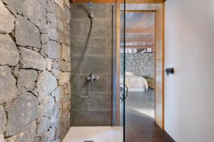 ein Bad mit einer Dusche und einer Steinmauer in der Unterkunft La Casita de la Orilla de Peñate in Santa Brígida