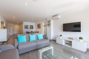 Una sala de estar con un sofá y un televisor. en Marbella Suites, en Marbella