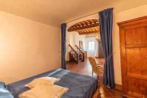 um quarto com uma cama e uma cadeira em um cômodo em Residenza d'epoca Alcova em Lucignano mais 20 fotografias