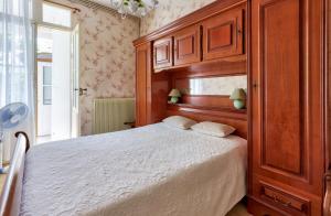 een slaapkamer met een bed en een grote houten kast bij Maisonnette Arcachon 250m plage in Arcachon