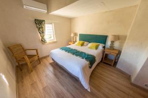 a bedroom with a bed and a chair and a window at Le Ventoux in Tulette