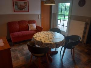 a living room with a table and chairs and a couch at Ruhe auf dem Lande in Westerstede
