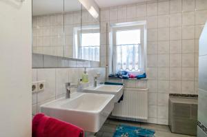 a white bathroom with a sink and a mirror at Arnold Laubbach in Ostrach +34 photos