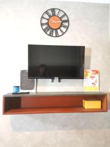 telewizor na półce z zegarem na ścianie w obiekcie Dancenter Airport Hotel - Grey Hotel w mieście Santol
