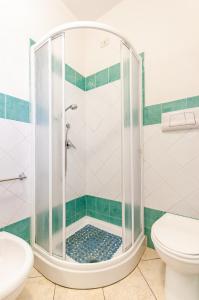 a shower with a glass door in a bathroom at Appartamento Pina Caletta sul mare con parcheggio privato in La Caletta