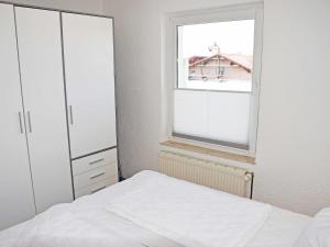 アルテフェーアにあるFerienwohnung Sundblickのベッドと窓のある寝室